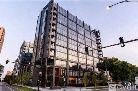 A modern glass building with a street in front of it.