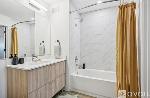 A bathroom with a white marble wall and a wooden vanity.