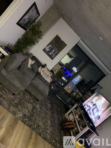 A living room with a grey couch and a television on a stand.
