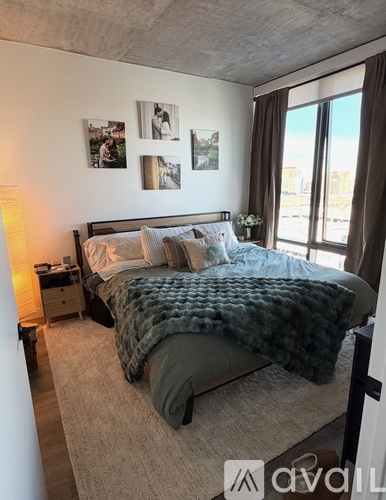 A bedroom with a large bed and a window with curtains.