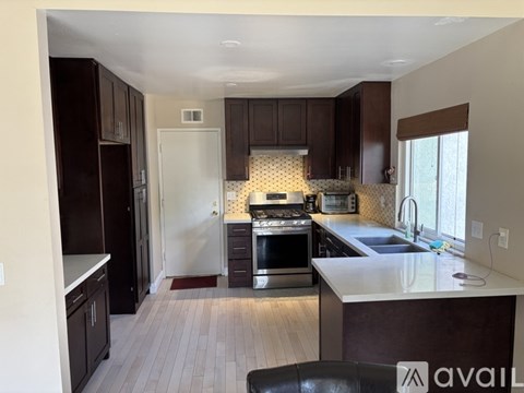 A kitchen with dark brown cabinets and a white refrigerator.