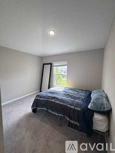 A bedroom with a bed and a window.