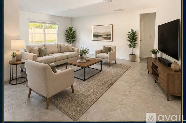 A living room with a large couch, a chair, a coffee table, and a television.