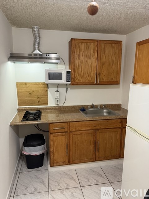 A kitchen with wooden cabinets and a white refrigerator.