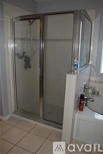 A bathroom with a glass shower door and a white sink.