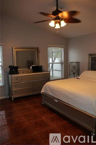 A bedroom with a bed, dresser, and mirror.