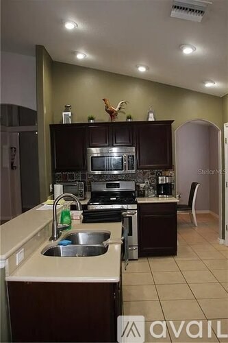 A kitchen with brown cabinets and a stainless steel sink.