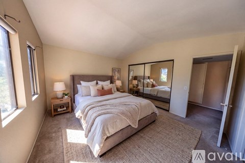 A bedroom with a large bed and a mirror on the wall.