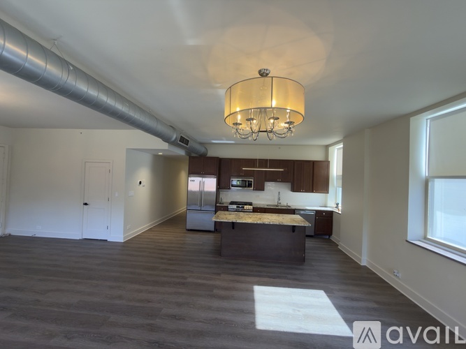 A large open space with a kitchen and a dining table.