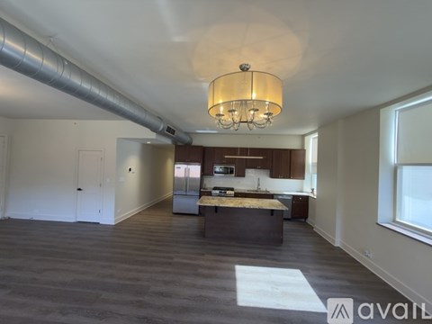 A large open space with a kitchen and a dining table.