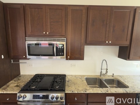 A kitchen with brown cabinets and a granite countertop.