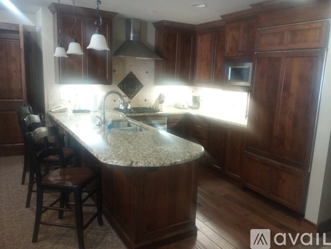 A kitchen with wooden cabinets and a granite countertop.