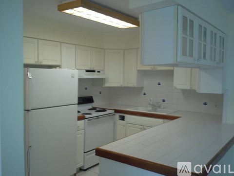 A kitchen with white appliances and cabinets.