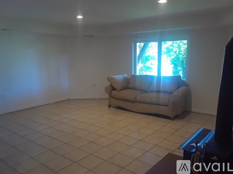 A living room with a couch and a window.