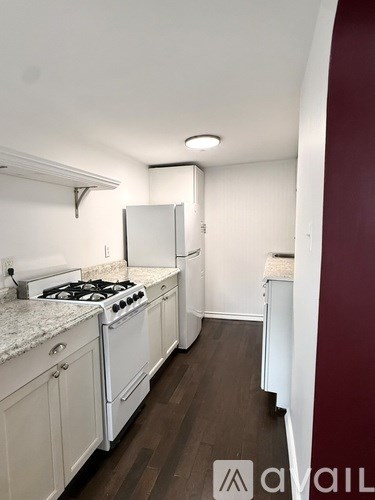 A kitchen with white appliances and cabinets.