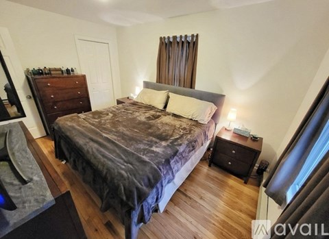 A bedroom with a bed, nightstand, and a dresser.