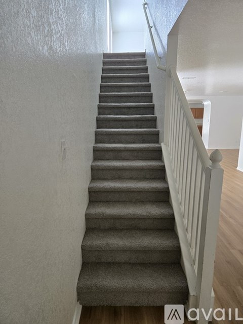 A staircase with a carpeted runner and white balusters.