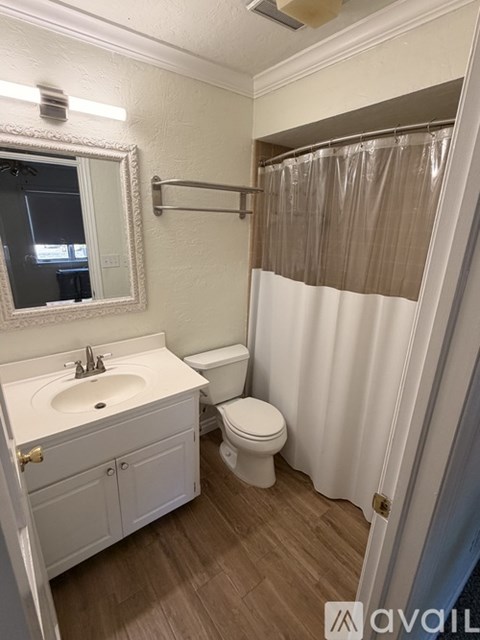 A bathroom with a white sink, toilet, and a white cabinet.