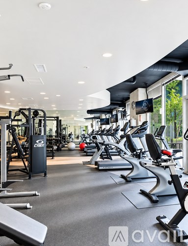 A gym with a variety of equipment including treadmills, weights, and exercise machines.