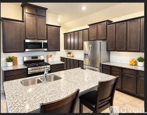 A kitchen with brown cabinets and a granite countertop.