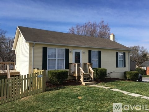 A small house with a wooden fence in front.