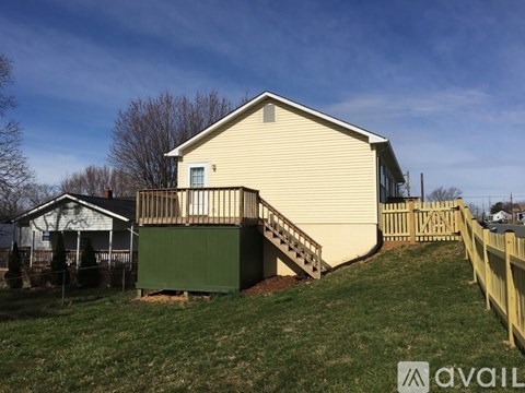 A house with a green garage door and a wooden fence.
