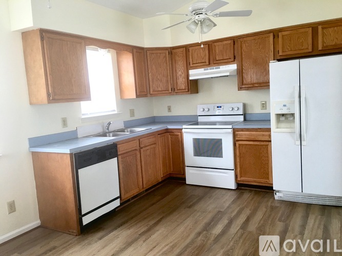 A kitchen with wooden cabinets and a white refrigerator.