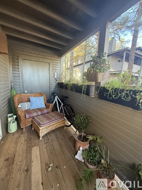 A wooden chair with a cushion and a pillow is on a wooden deck.