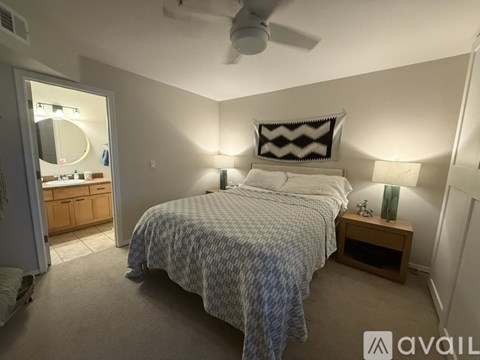 A bedroom with a bed, nightstand, and a ceiling fan.