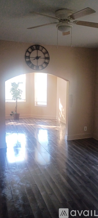 A room with a ceiling fan and a clock on the wall.