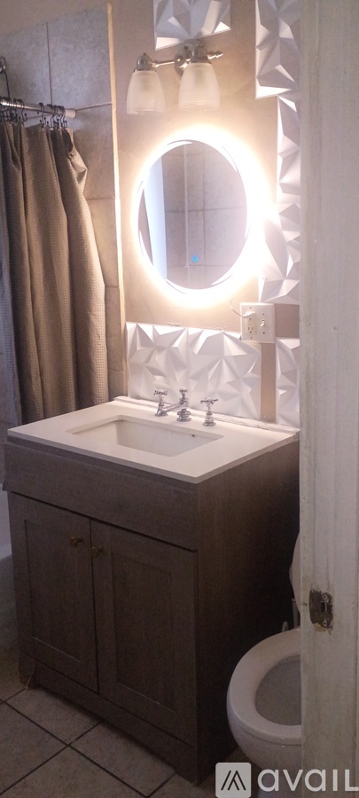 A bathroom with a brown cabinet and a white sink.
