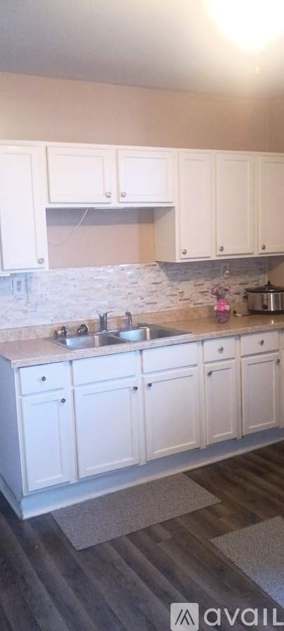 A kitchen with white cabinets and a marble countertop.