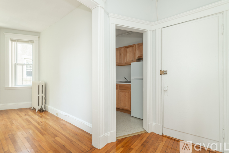 A room with a white door, a window, and a radiator.