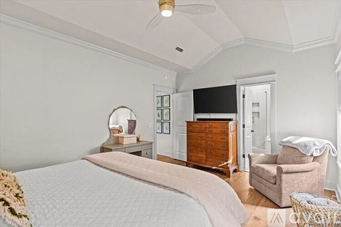 A bedroom with a large bed and a wooden dresser.