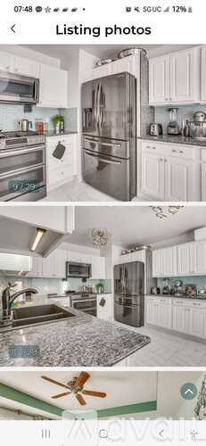 A modern kitchen with white cabinets and stainless steel appliances.