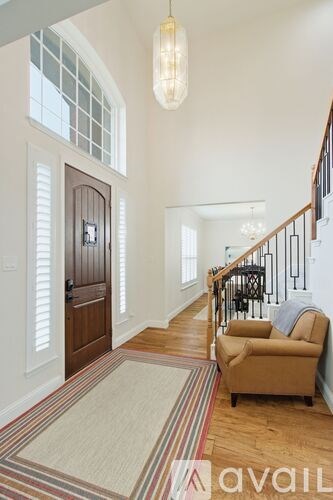 A living room with a striped rug and a tan couch.