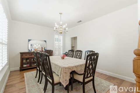 A dining room with a table set for six people.