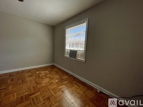 A room with wooden flooring and a window.