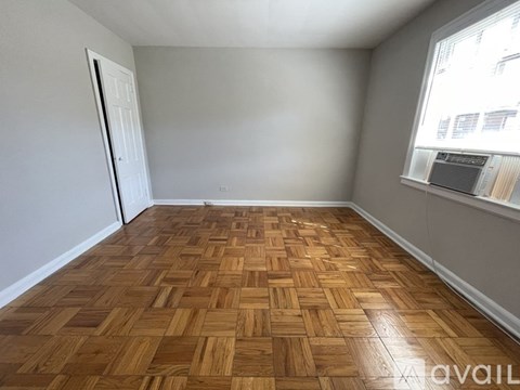 A room with wooden flooring and a window.