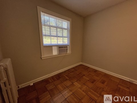A room with a window and wooden flooring.