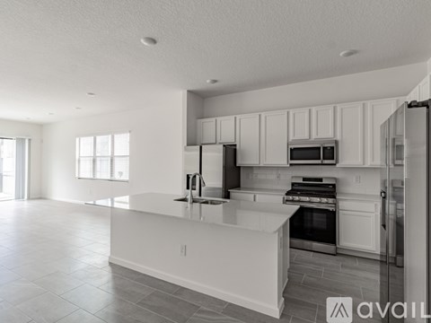 A modern kitchen with white cabinets and stainless steel appliances.