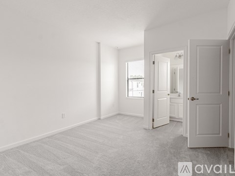 A room with a carpeted floor and two doors.