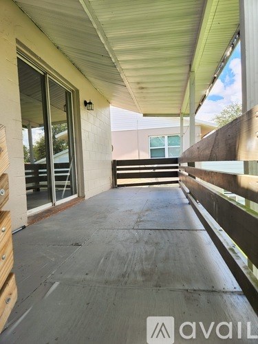 A patio with a wooden railing and a sliding glass door.