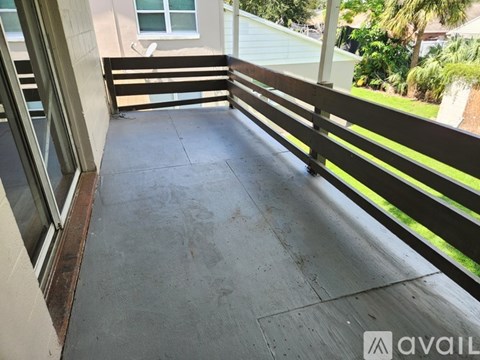 A balcony with a wooden railing and a concrete floor.