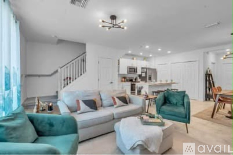 A living room with a white couch, a green armchair, and a coffee table.
