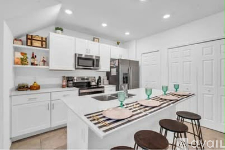 A kitchen with white cabinets and a white island with a striped table runner.