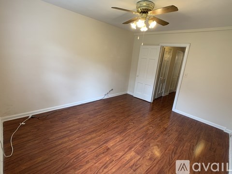 A room with wooden flooring and a ceiling fan.