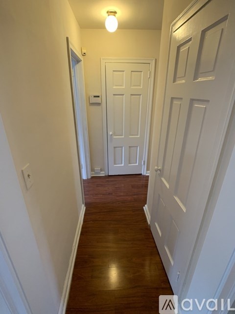 A hallway with white doors and a light on.
