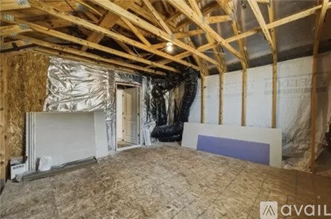 A room under construction with wooden beams and insulation on the walls.