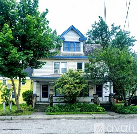 A two-story house with a blue roof and white walls.